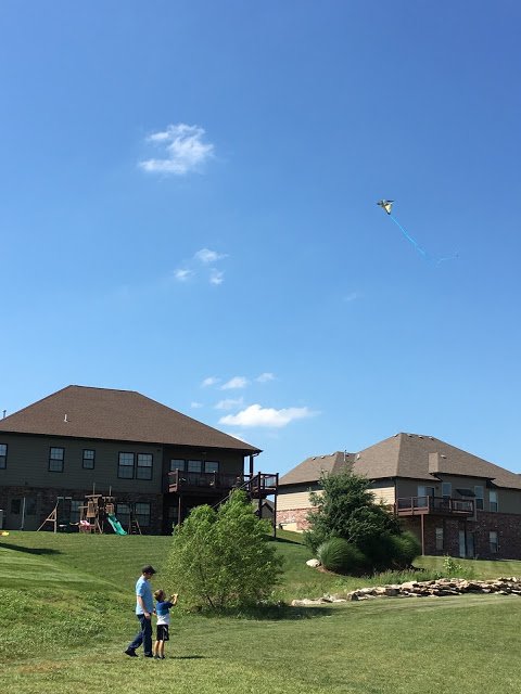 Dad and sons flying kite 