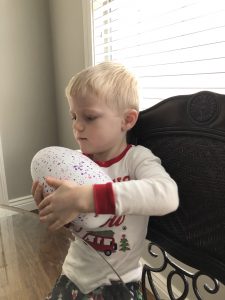 Little boy with Hatchimal Christmas Morning 