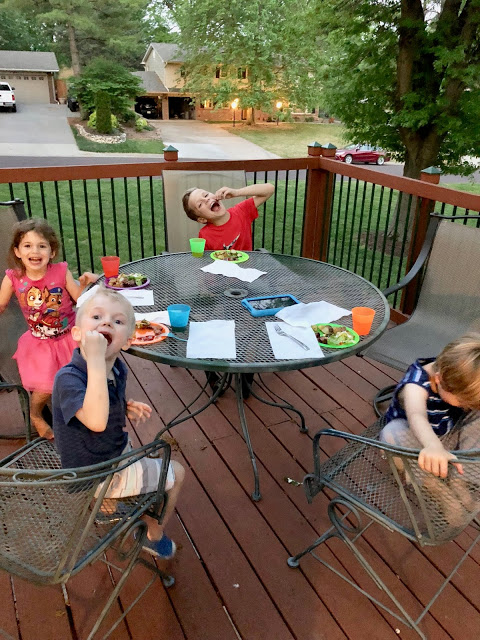 Little kids eating dinner on a patio