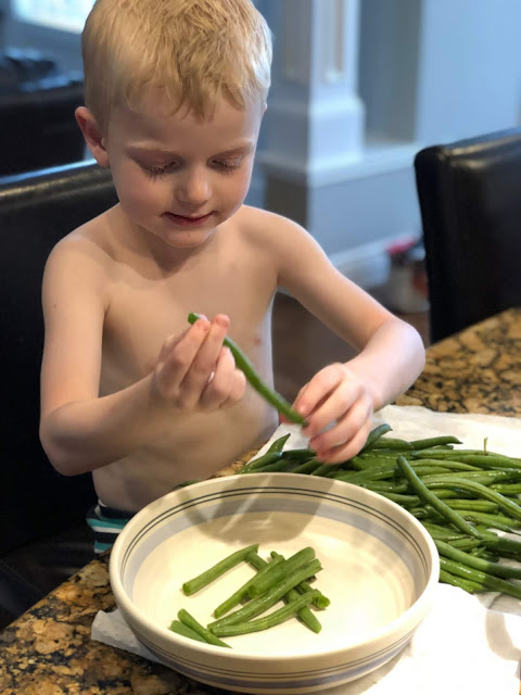 Little boy snapping green beans 