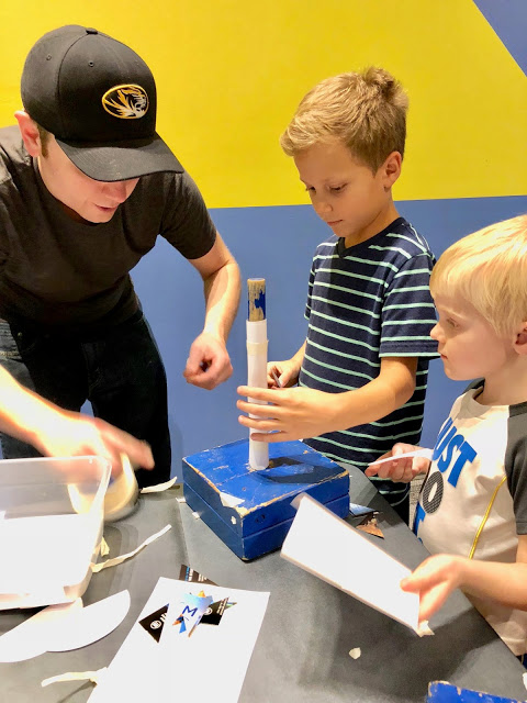 Father and Sons building paper airplanes at the Science Center of Iowa