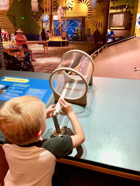Little boy launching paper airplane at the Science Center of Iowa