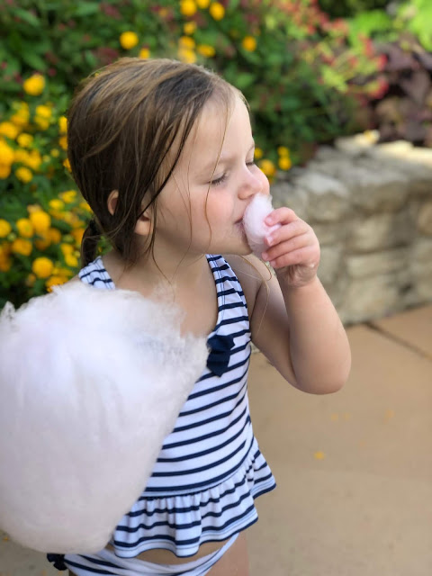 Little girl eating Cotton Candy by the Pool 