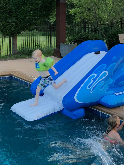 Little boy on inflatable pool Waterslide 