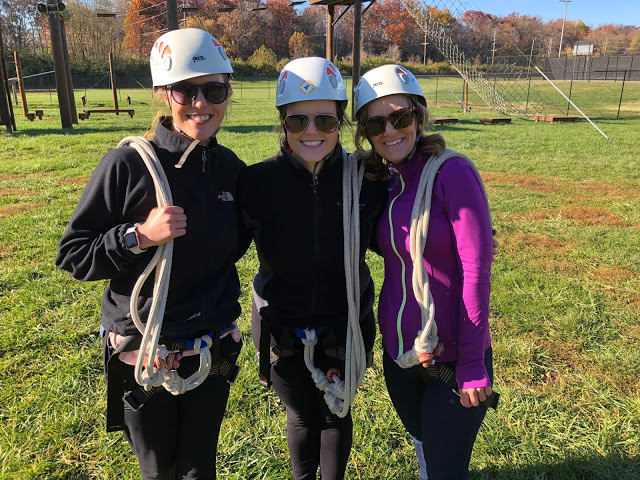 Women in zip lining gear completing a ropes course 